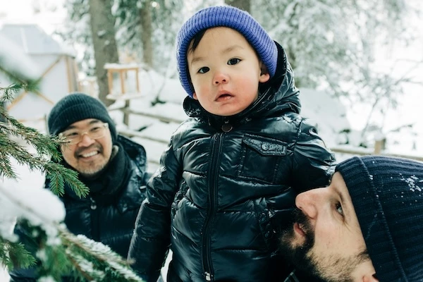 Parents with child enjoying outdoor activity in the snow