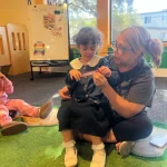 Teacher providing one-on-one attention at San Leandro, California preschool