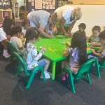 Teachers leading group art project at East Bay, California preschool