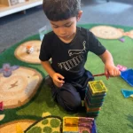 Toddler building with magnetic tiles at East Bay, California preschool