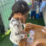 Toddler exploring water sensory play at San Leandro, California preschool