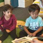 Toddlers during story time circle at San Leandro, California preschool
